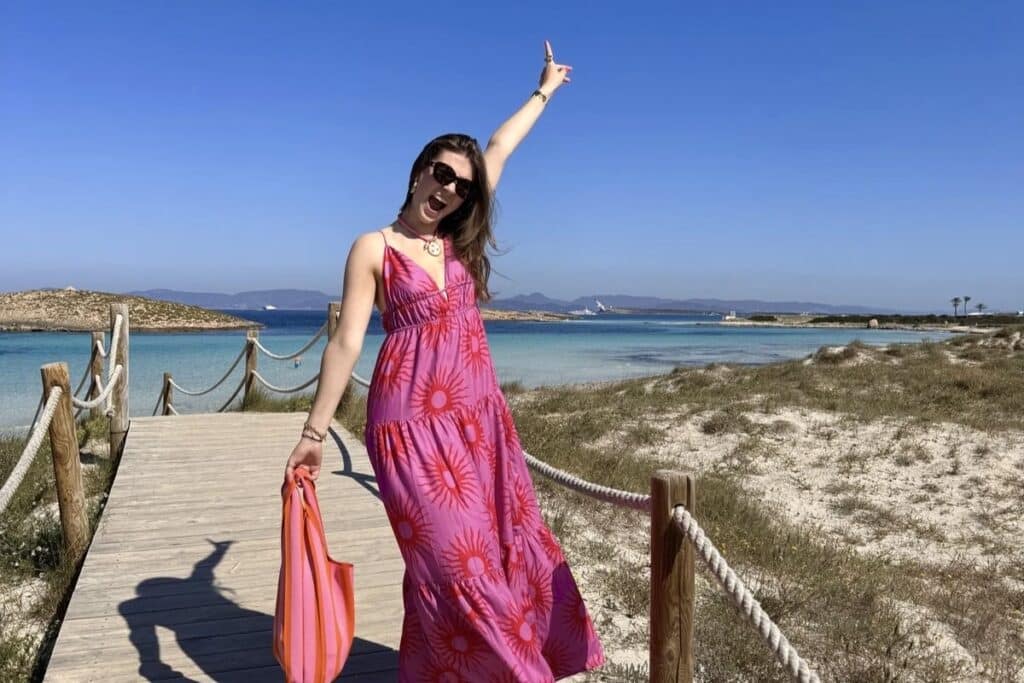 Traveler walking along a scenic beach boardwalk in Formentera during a coastal route